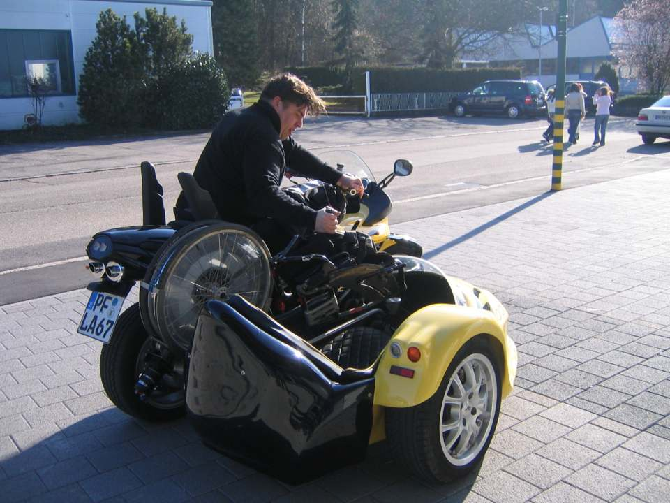 person in a Wheelchair control the parts of his chair on a sidecar motocycle